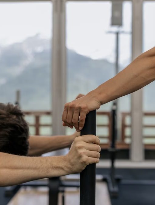 A couple working out together at an indoor gym with mountain views.